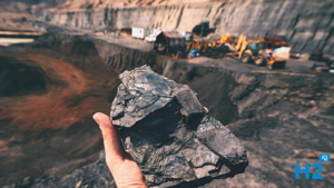 Image of a coal mine and a man holding a lump of coal