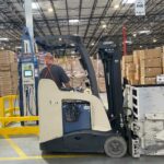 Hydrogen fuel cell powered electric forklift, with hydrogen dispenser in the background