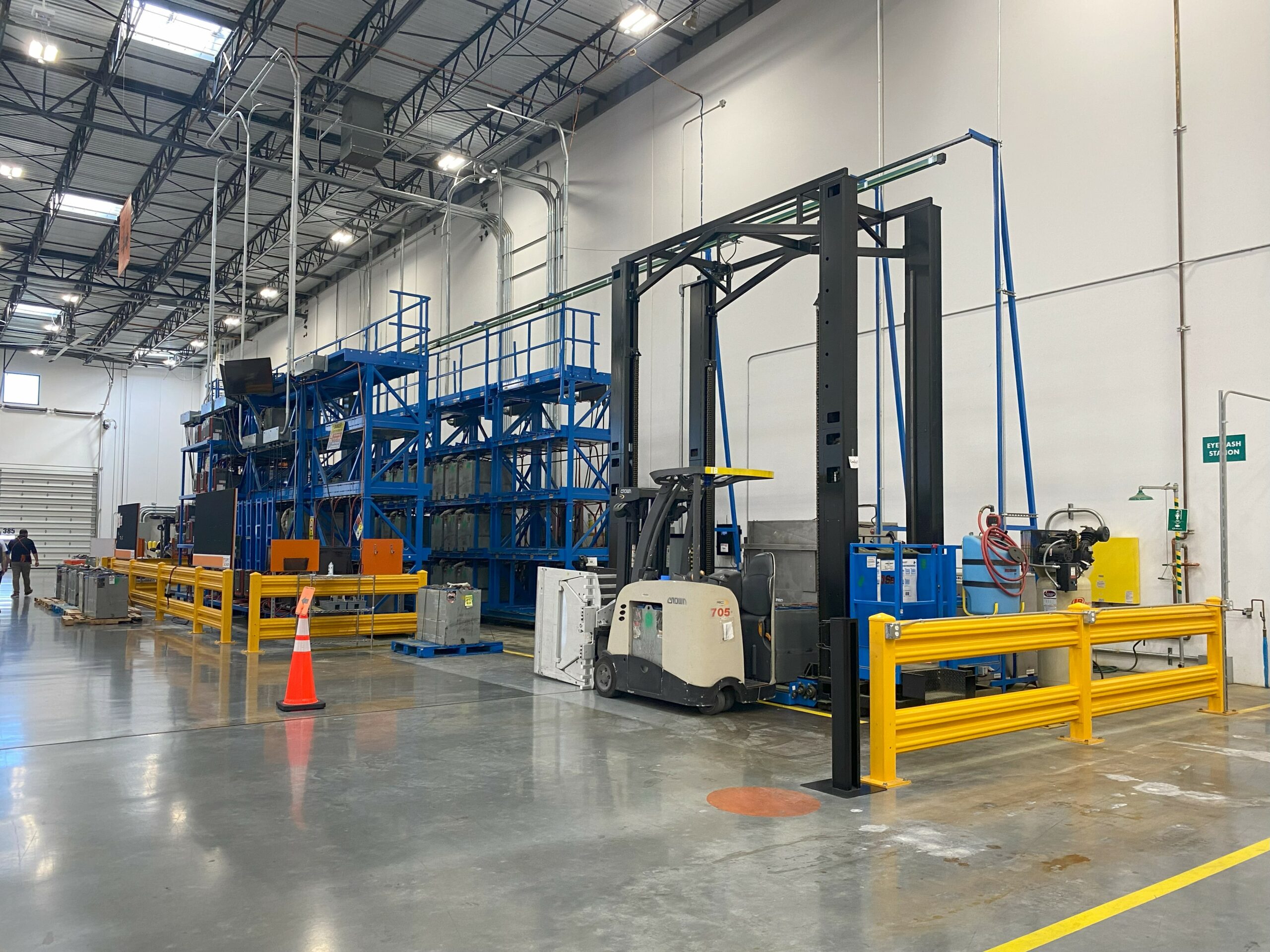 Battery powered forklift waiting to exchange a battery using a multi-level battery changing system