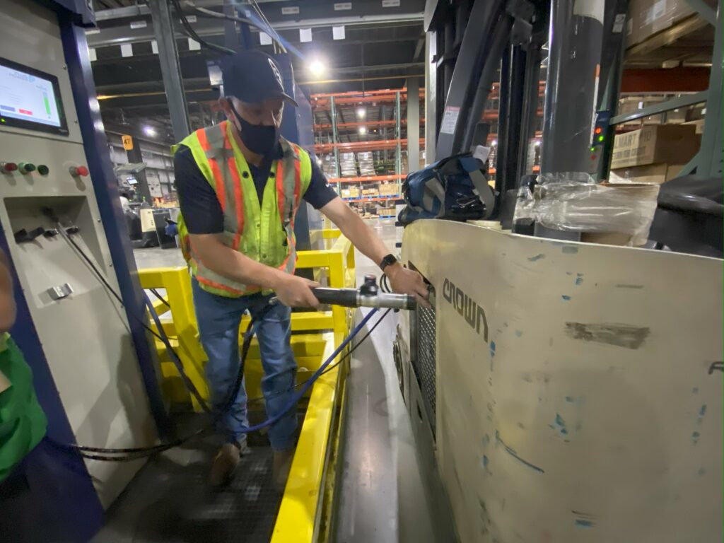 Worker refueling a hydrogen fuel cell in a forklift in 3 minutes