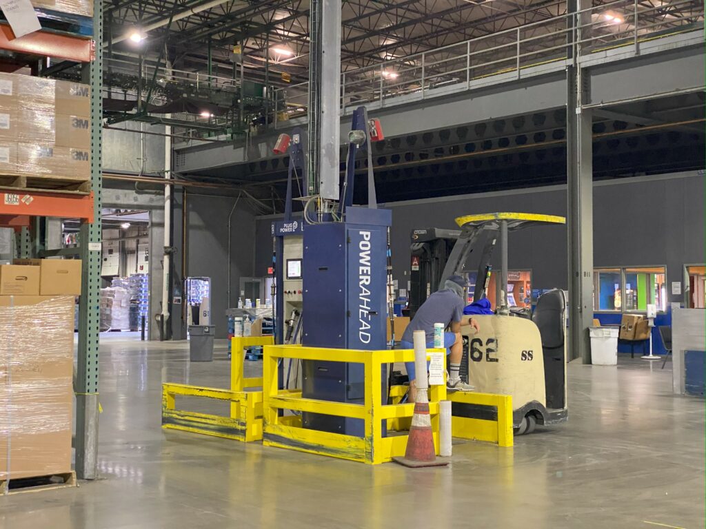 Worker refueling a hydrogen fuel cell in at a Walmart distribution center