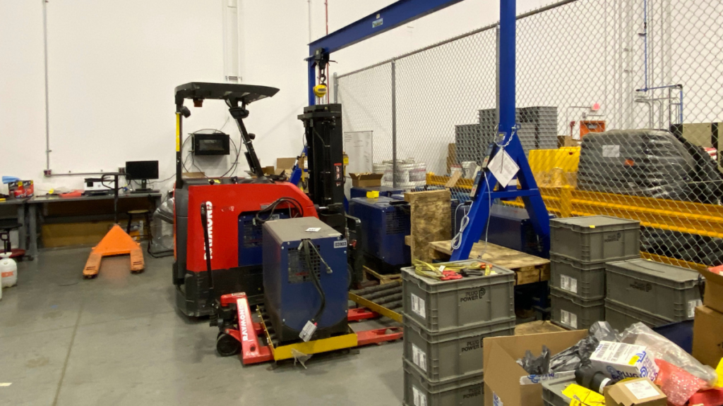 A hydrogen fuel cell being placed into a forklift.